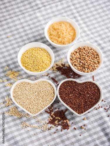 Gluten free grains quinoa, rice, buckwheat, amaranth, millet in bowls on kitchen table. Celiac diet