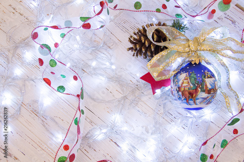 Christmas or New Year background:  colorful glass balls, decoration and glittering stars on white wood, top view, copy space.