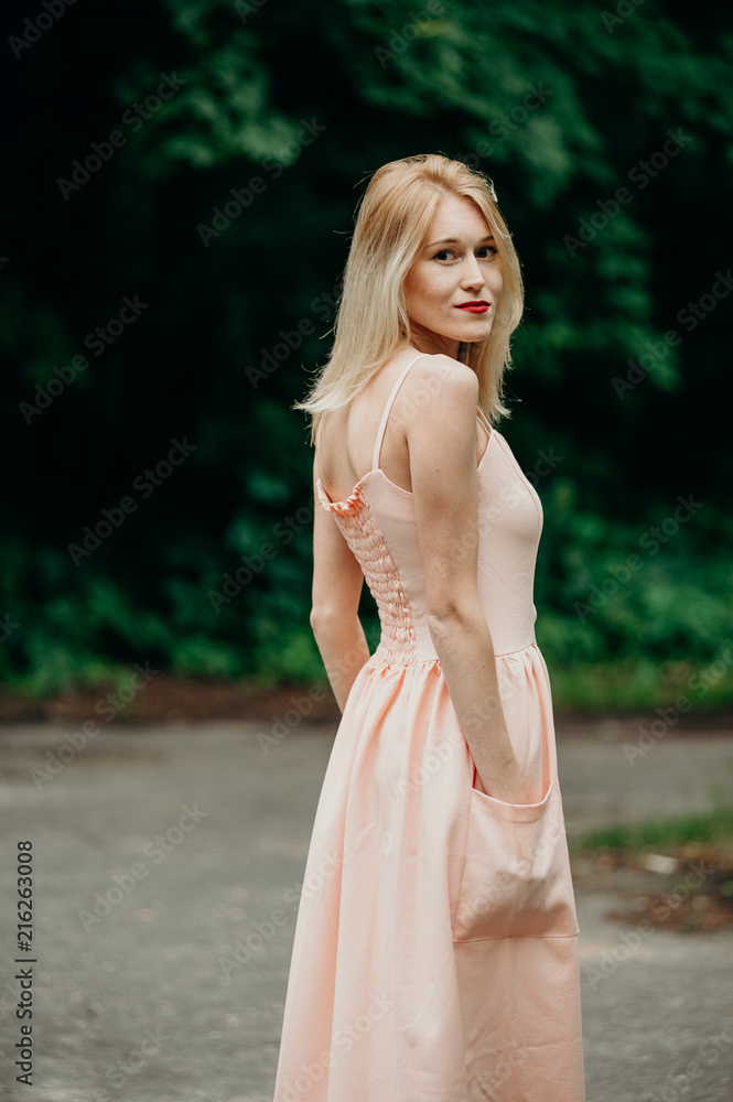 Feelings and vacation. Beauty romantic girl outdoor. Pretty young model dressed in long pink dress posing outdoors in the park. Feelings and vacation. Beauty romantic girl outdoor. Pretty young model dressed in long pink dress posing outdoors in the park.