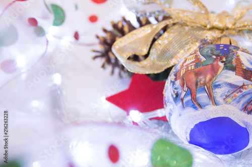 Christmas or New Year background:  colorful glass balls, decoration and glittering stars on white wood, top view, copy space.