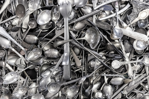 Silver spoons in a pile in a shop.