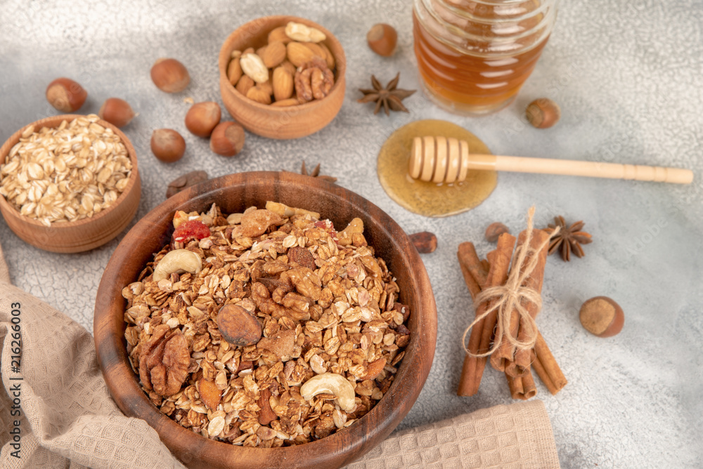 Homemade granola in wooden bowl with ingredients - oat, nuts, honey and spice cinnamon and anise Homemade granola in wooden bowl with ingredients - oat, nuts, honey and spice cinnamon and anise