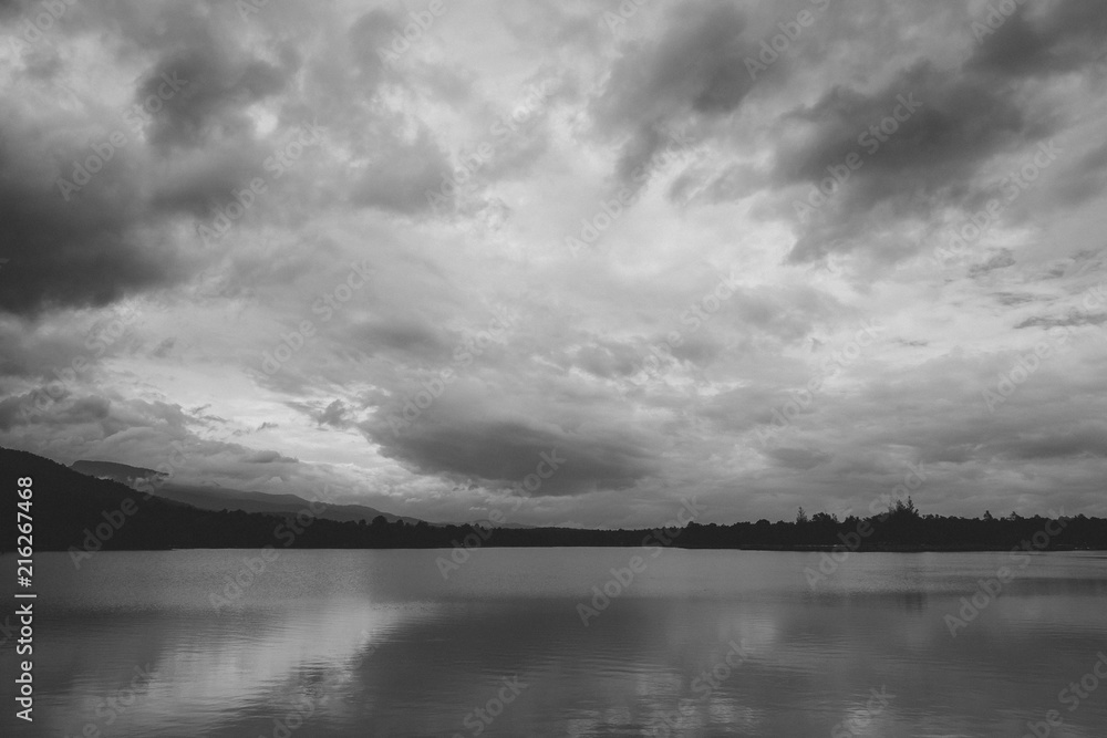 Fototapeta premium Black and white image of a beautiful lake with sky and mountain background