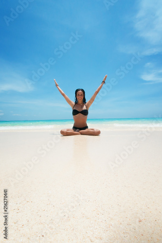 Yoga woman meditating at serene tropical beach, morning zen mediation