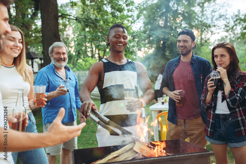 Fototapeta premium Group of friends making barbecue in the backyard. concept about good and positive mood with friends