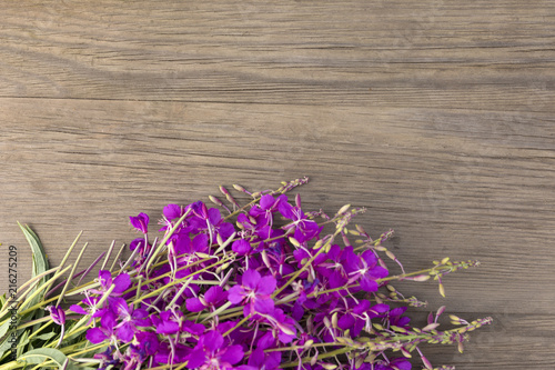 Willow-herb purple flowers on old grunge wooden background. Top view. Minimalistic mockup.