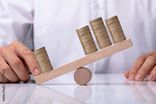Quadro em tela Businessperson Showing Unbalance Between Stacked Coins