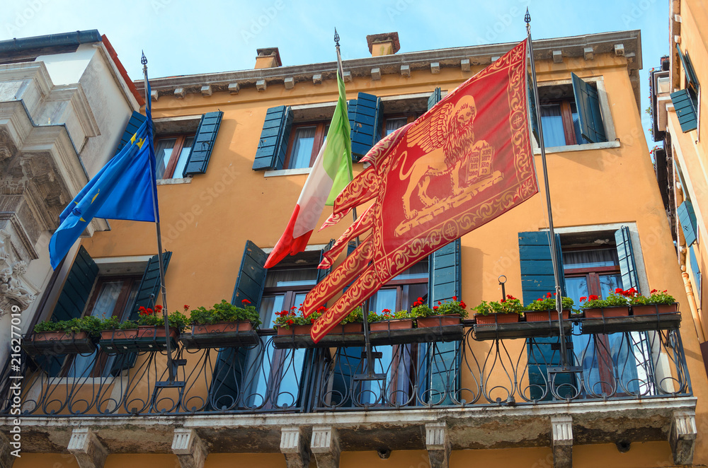 VENICE ITALY - SEPTEMBER 29, 2017: The Venice flag with St. Mark's lion on the facade of the house in Venice.