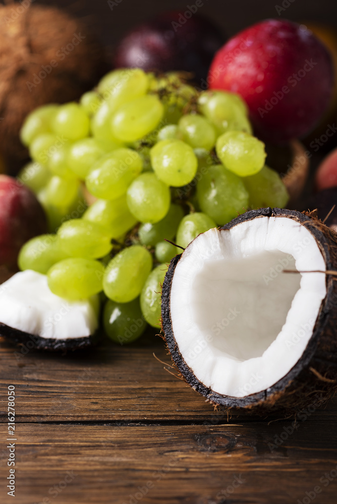Concept of vegan food with coconut, grape, peache and plums Concept of vegan food with coconut, grape, peache and plums