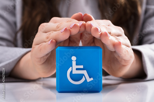 Woman Protecting Cubic Block With Disabled Handicap Icon
