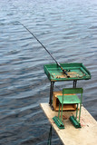 Fishing tackle, rod with line and reel. Angling equipment left on a self-made platform.