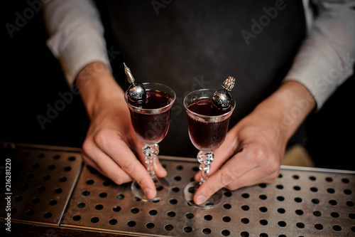 Top view bartender holding two red delicious cocktails