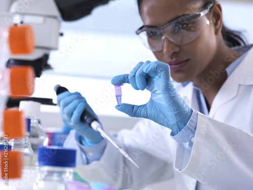 Genetic research, female scientist viewing sample in a eppendorf vial, analysis in the laboratory photo