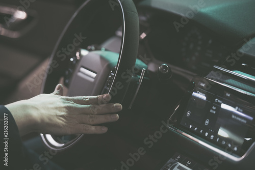 Man hand on a steering wheel of a modern car