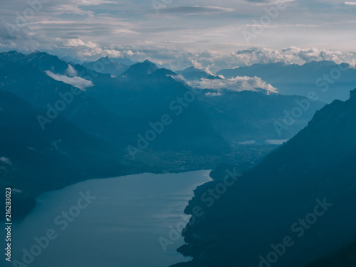 view from the peak of mountain to a blue lake covered in clouds  brienzer rothorn switzerland alps