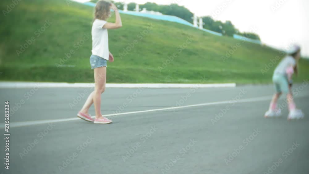 Mom and daughter ride on roller skates. Girl learning to roller skate, and falls. Mom teaches daughter to ride on rollers Mom and daughter ride on roller skates. Girl learning to roller skate, and falls. Mom teaches daughter to ride on rollers
