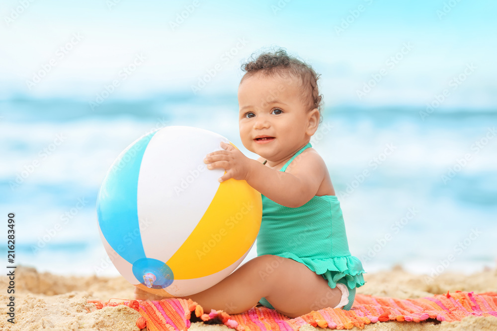 Obraz premium Adorable African-American girl playing on beach