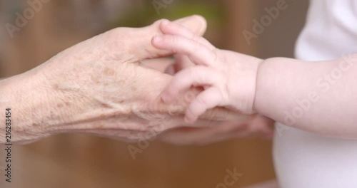 Babyhands touching senior hands photo