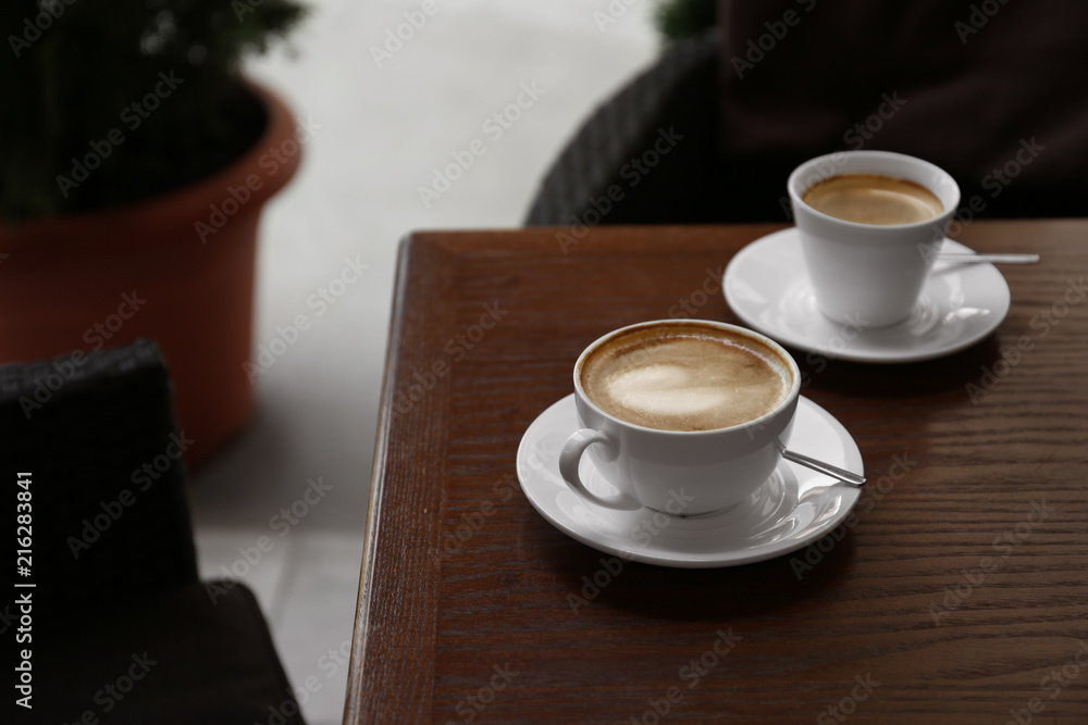 Cups of delicious aromatic coffee on table