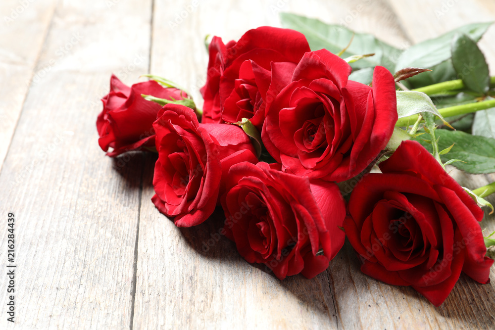 Beautiful red rose flowers on wooden background Beautiful red rose flowers on wooden background