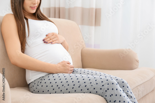 Pregnant woman holding hand...