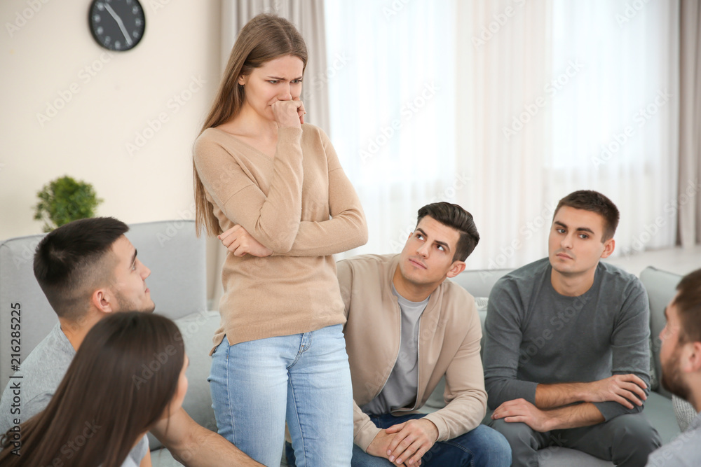 Young woman talking about her problems during group therapy Young woman talking about her problems during group therapy