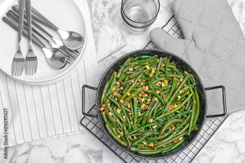 Yummy green beans with almonds in serving pan on table