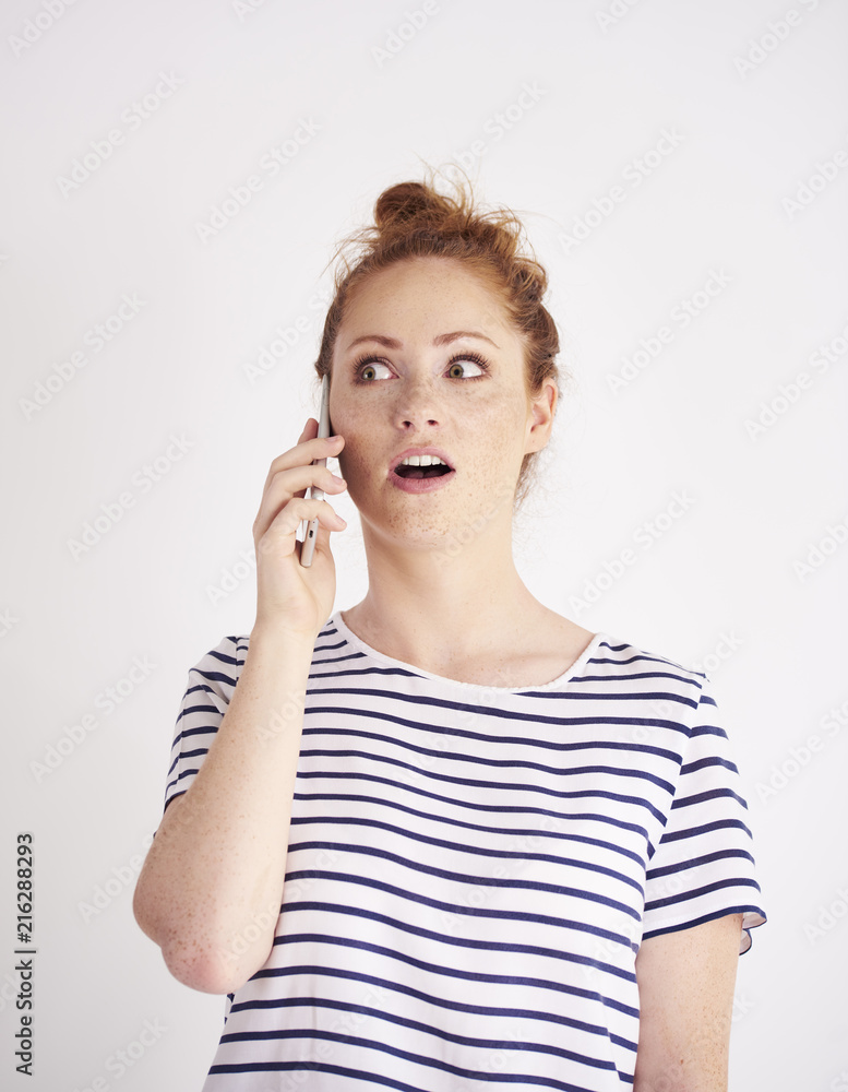 Shocked woman talking by mobile phone at studio shot Shocked woman talking by mobile phone at studio shot