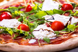 close up of delicious italian pizza with ham, mozzarella and tomatoes