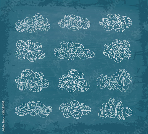 Set of doodle clouds on chalkboard background. Vector hand-drawn clouds in a linear style. Sketch.