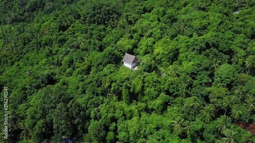 Aerial View of Hermitic House Standing Apart in Remote Isolated Location among Tropical Forest photo