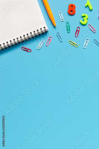 Notebook, pen, colorful numbers on blue background.