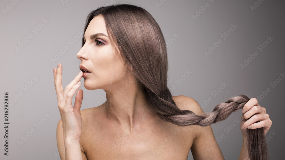 Sexy portrait of a young lady with long and healthy purple hair touching her lips with fingers. - obrazy, fototapety, plakaty 