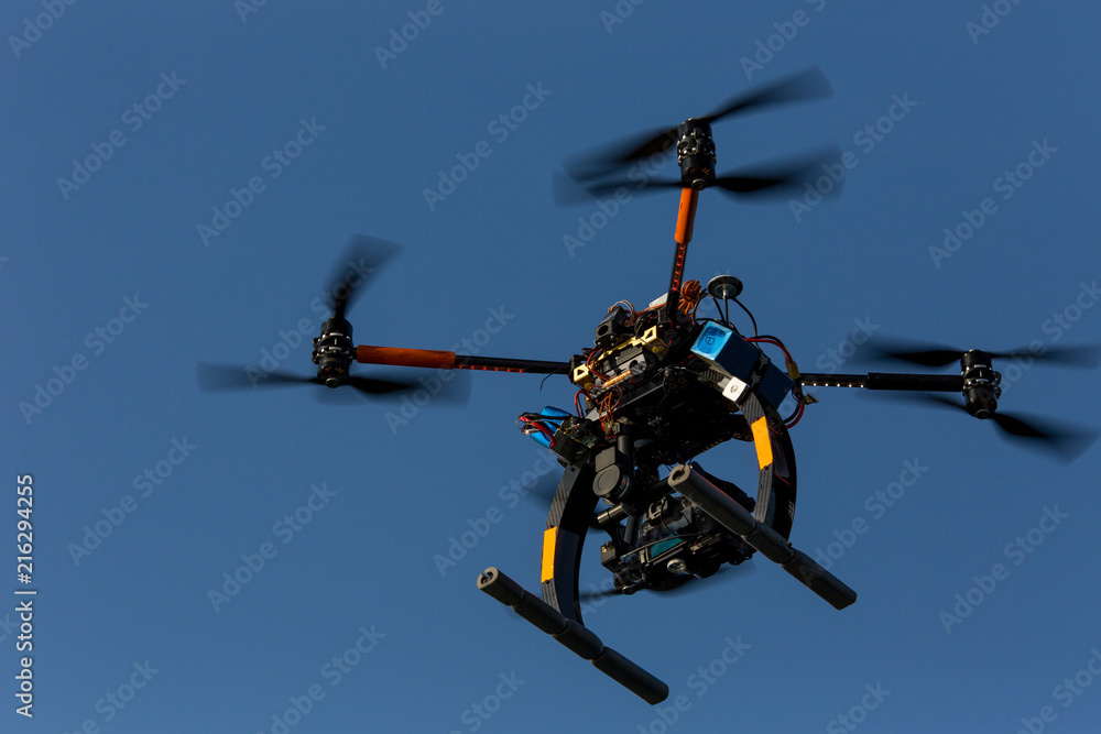 Flying drone with camera on the sky. Drone with a large camera flies in the sky and recording the environment. Multirotor RC helicopter Flying drone with camera on the sky. Drone with a large camera flies in the sky and recording the environment. Multirotor RC helicopter