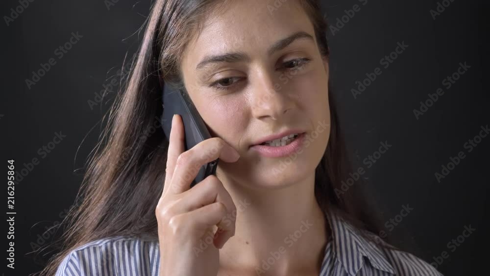 Portrait of young happy woman talking on phone and smiling, isolated on black background Portrait of young happy woman talking on phone and smiling, isolated on black background