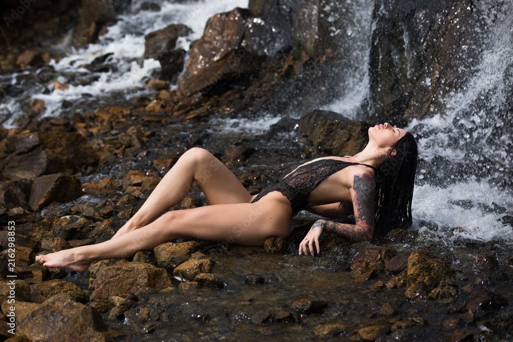 Model in sexy underwear under waterfall