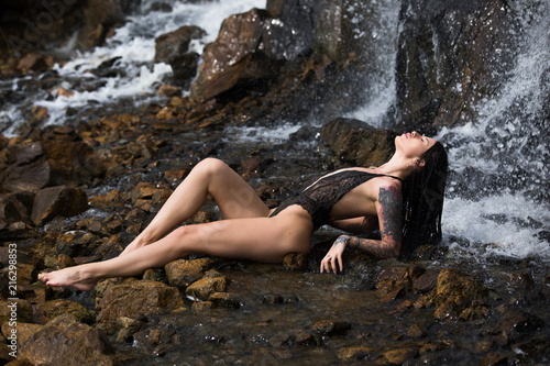 Model in sexy underwear under waterfall