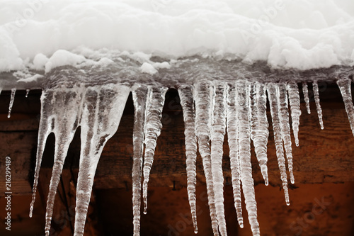 Icicles on the roof, frozen water. cold winter weather concept, soft focus, shallow depth of field. macro front view.