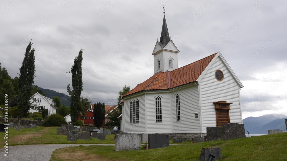 Weiße Holzkirche und Friedhof in Tjugum, Norwegen