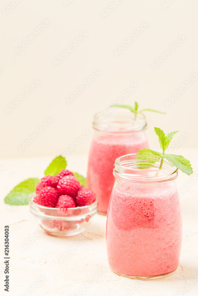 Raspberry smoothie close up photography with fresh summer blended cocktail and ripe berries on pastel yellow background. Raspberry smoothie close up photography with fresh summer blended cocktail and ripe berries on pastel yellow background.