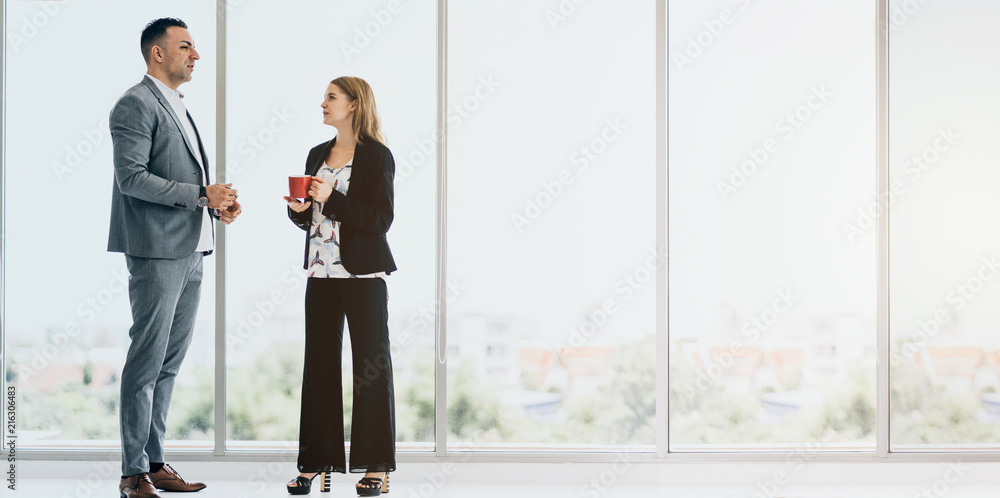 two business partner causual meeting near big window after conference