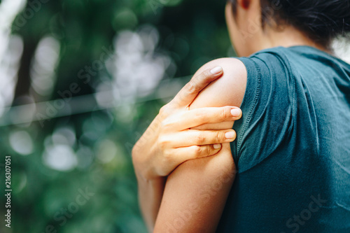 Woman with pain in shoulder and upper arm. Ache in human body, Office syndrome concept. photo