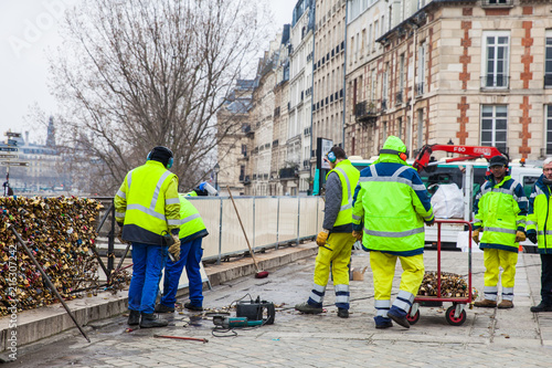 Group of workers removing padlocks at Pont Neuf in Paris