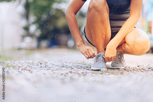 young woman runner tying shoelaces . Sport lifestyle.