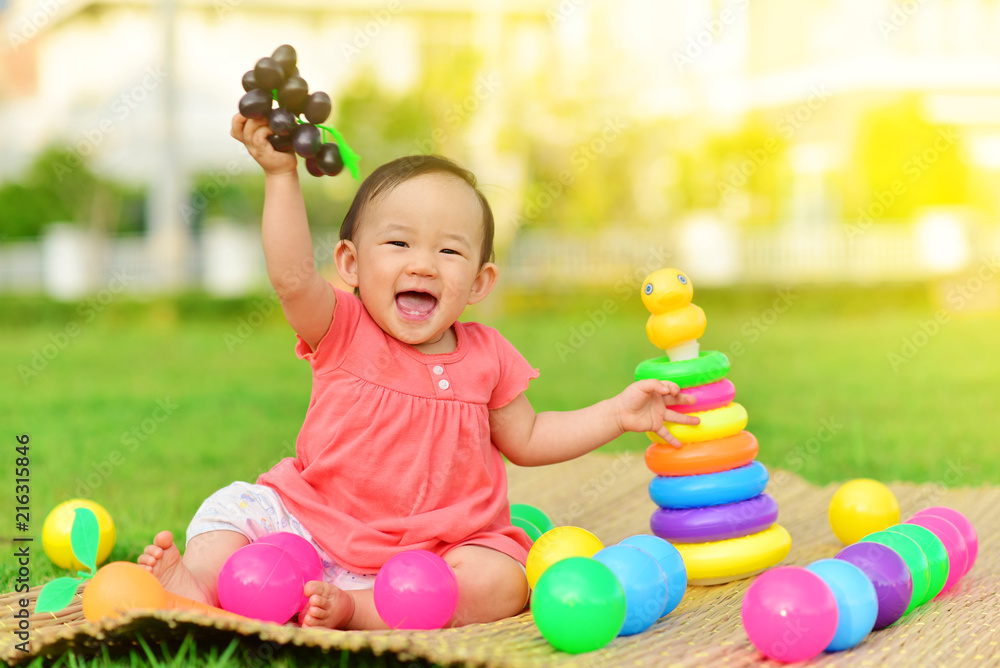 Obraz premium Cute Asian baby playing with toys in playground