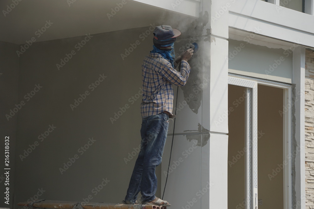 Worker is use abrasive equipment to decoration surface the house.