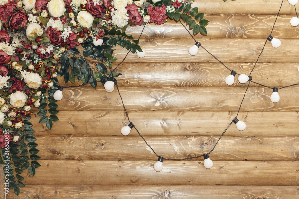 Obraz premium Decoration for wedding ceremony on wooden background with lamp garland. copy space