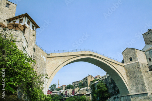 Old Bridge of Mostar during a sunny afternoon, with the old city visible in the background. This bridge is the symbol of the war torn main city of Herzegovina, in Bosnia..