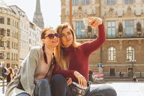 Two young woman taking selfie on smartfone photo