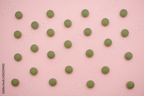 chlorella tablets on pink background